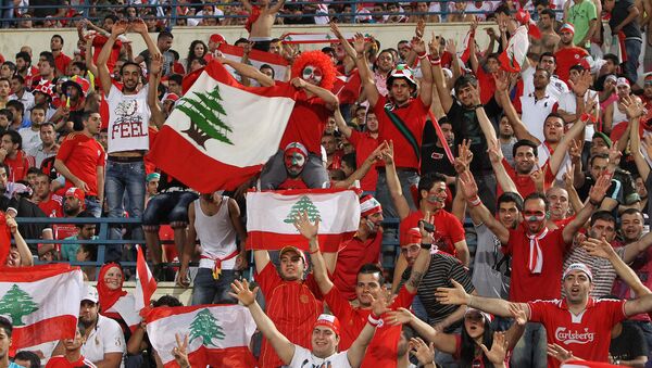 Ливанские футбольные фанаты поддерживают свою национальную команду во время отборочного матча азиатского чемпионата мира 2014 года против национальной сборной Катара (3 июня 2012). Бейрут - Sputnik Армения
