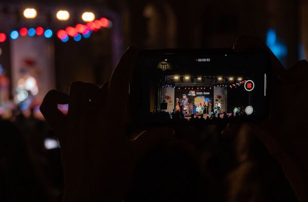 Зритель концерта в честь 70-летия Рубена Ахвердяна во дворе церкви Сурб Катогике записывает на видео песню Ереванская ночь (29 августа 2020). Еревaн - Sputnik Армения