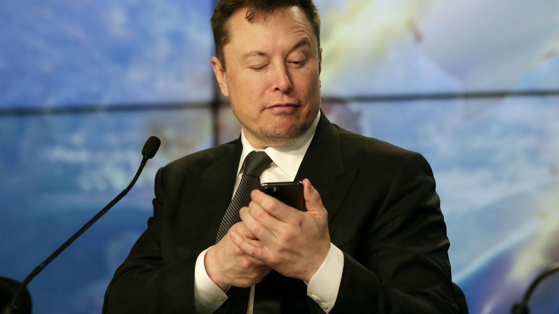 Основатель SpaceX Илон Маск шутит с журналистами, делая вид, что ищет ответ на вопрос по мобильному телефону во время пресс-конференции после испытательного полета ракеты Falcon 9 SpaceX (19 января 2020). Флорида - Sputnik Արմենիա, 1920, 08.04.2021