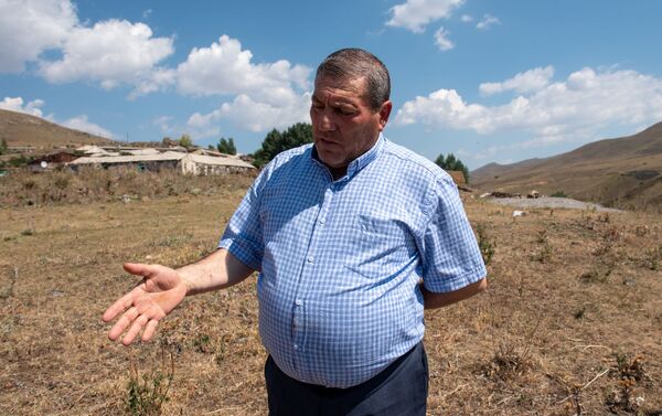 Глава села Джрадзор Геворик Овакян на фоне села рассказывает о планах переселения - Sputnik Армения