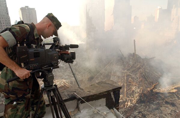 Оператор во время съемки разрушений на месте Всемирного торгового центра после атаки в Нью-Йорке - Sputnik Армения