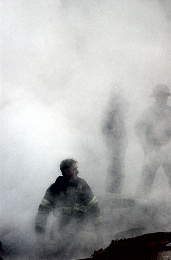 Пожарный в дыму от разрушения Всемирного торгового центра 11 сентября в Нью-Йорке - Sputnik Армения