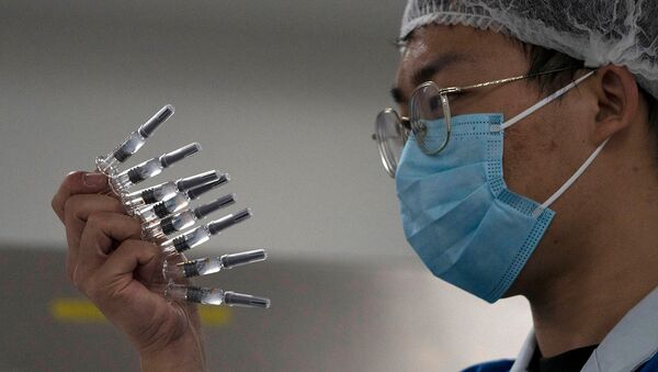 Сотрудник вручную проверяет шприцы с вакциной SARS CoV-2 от COVID-19, производимые SinoVac на ее заводе (24 сентября 2020). Пекин - Sputnik Армения