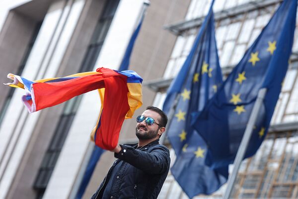 Молодой человек с флагом Армении во время акции протеста армянских общин Европы возле штаб-квартиры Европейской комиссии в Брюсселе (7 октября 2020). Бельгия - Sputnik Армения