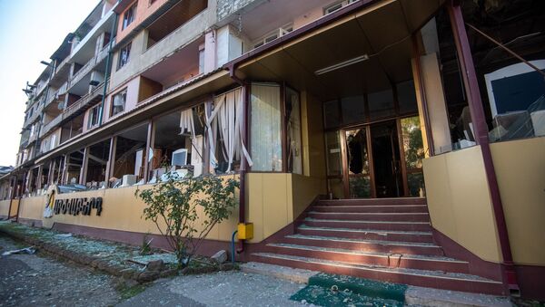 Вид на попавший под обстрел ВС Азербайджана жилой дом из окна пострадавшего мебельного магазина в Степанакерте, Карабах - Sputnik Армения