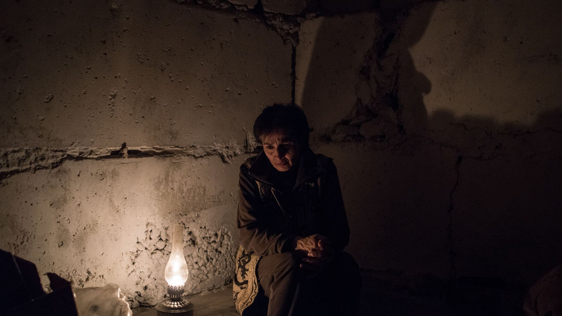 Женщина у керосиновой лампы в подвале дома из-за обстрелов Степанакерта (19 октября 2020). Карабах - Sputnik Արմենիա, 1920, 14.03.2021