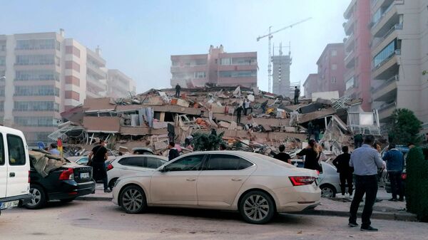 Спасатели и горожане у рухнувшего здания в Измире после сильного землетрясения в Эгейском море (30 октября 2020). Турция - Sputnik Армения