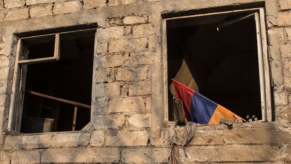 Флаг в окне разрушенного вследствие обстрелов дома в Мартакерте (30 октября 2020). Карабах - Sputnik Армения