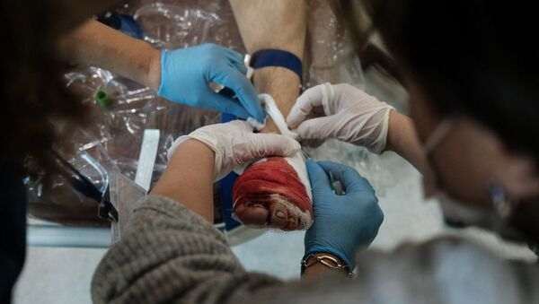 Медработники оперируют раненного мужчину во время обстрелов медицинского центра Степанакерта (28 октября 2020). Карабах - Sputnik Армения