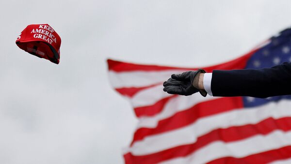 Президент США Дональд Трамп бросает кепку с надписью Keep America Great во время предвыборного митинга в Международном аэропорту округа Окленд (30 октября 2020). Штат Мичиган - Sputnik Армения