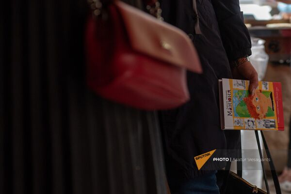 Девушка с книгой Нарине Абгарян Манюня в очереди за женгялов хацем на улице Московян (6 ноября 2020). Еревaн - Sputnik Армения