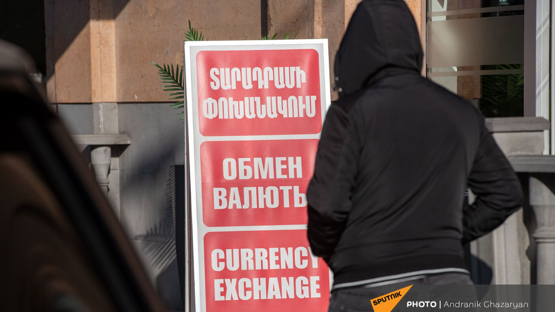 Люди проходят мимо вывески пункта обмена валюты в Ереване - Sputnik Армения, 1920, 19.04.2021