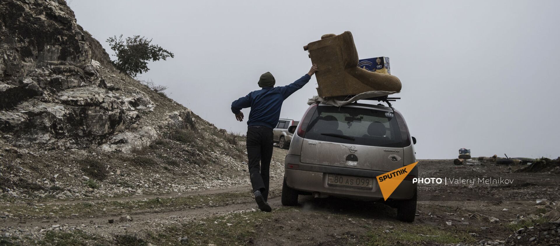 Мужчина с перегруженным вещами автомобилем покидает свой дом в городе Бердзор (30 ноября 2020). Карабах - Sputnik Արմենիա, 1920, 16.02.2021