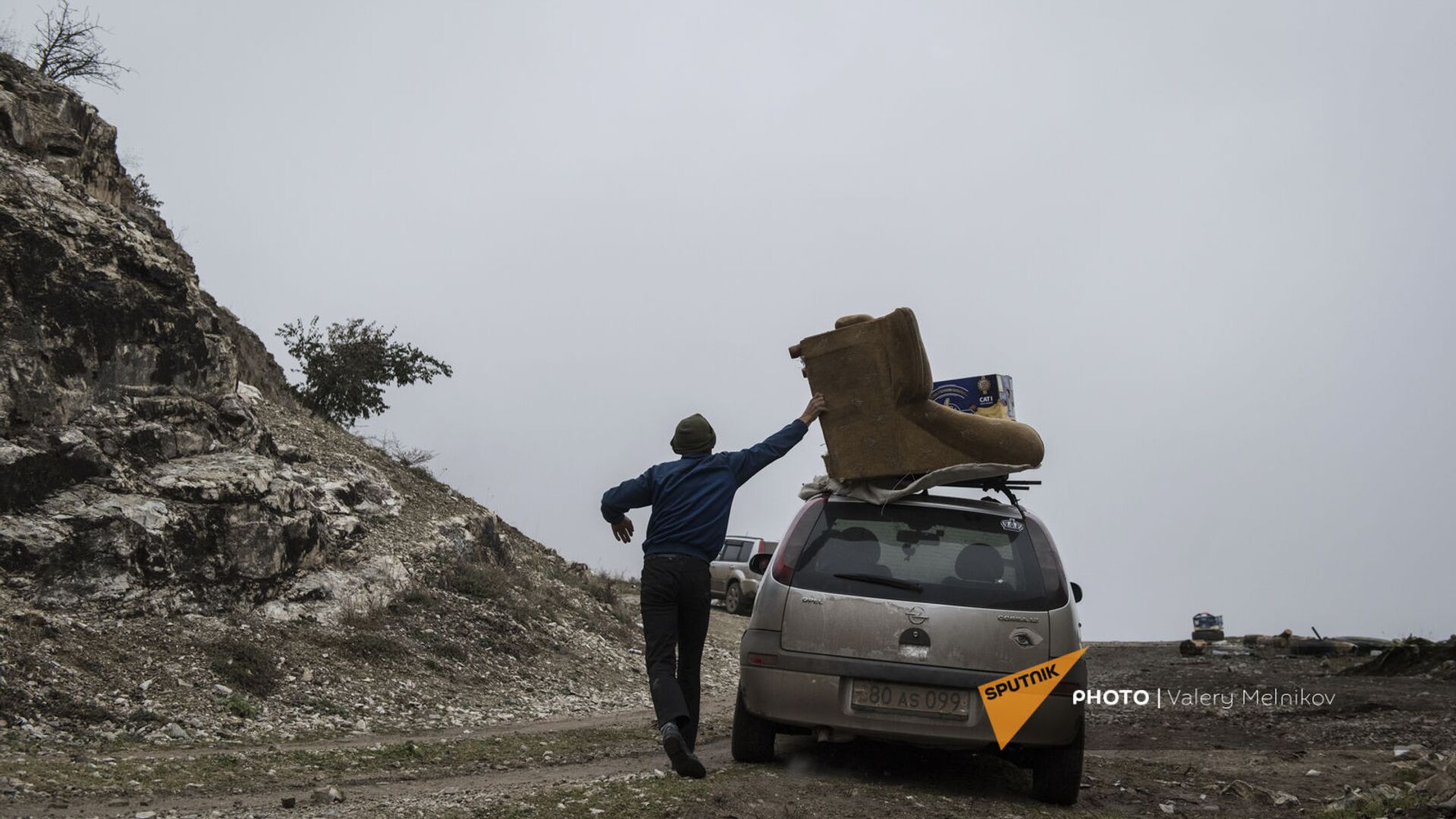 Мужчина с перегруженным вещами автомобилем покидает свой дом в городе Бердзор (30 ноября 2020). Карабах - Sputnik Արմենիա, 1920, 16.02.2021