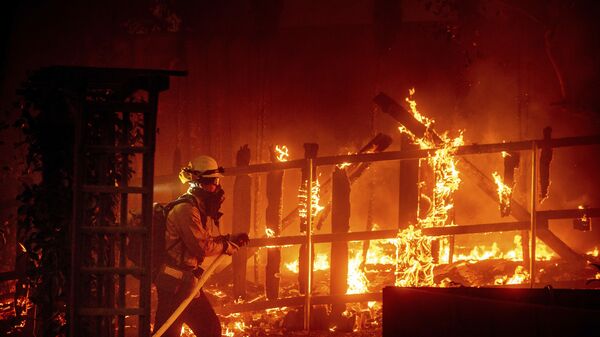 Пожарный борется с пламенем, охватившем постройку, в округе Ориндж, штат Калифорния - Sputnik Армения