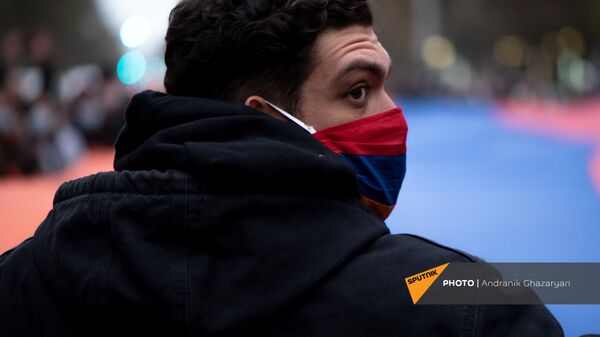 Молодой человек в маске с армянским триколором во время митинга оппозиции с требованием отставки премьер-министра (5 декабря 2020). Еревaн - Sputnik Արմենիա