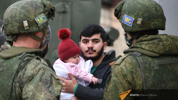 Мужчина с ребенком стоит рядом с российскими миротворцами, доставивишие воду в населённые пункты Аскеранского района - Sputnik Արմենիա