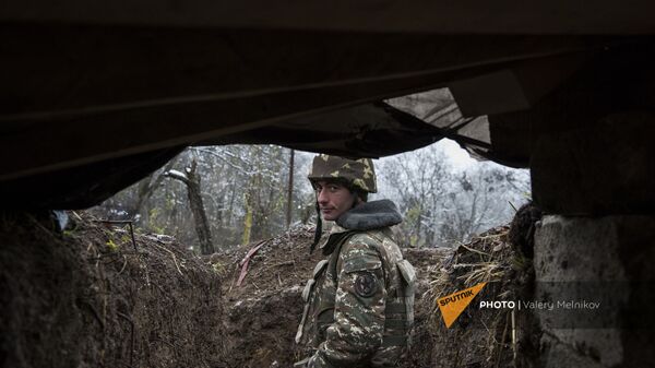 Военнослужащий армии обороны Карабаха на одной из улиц в селе Тагавард Мартунинского района (11 декабря 2020). Карабах - Sputnik Армения