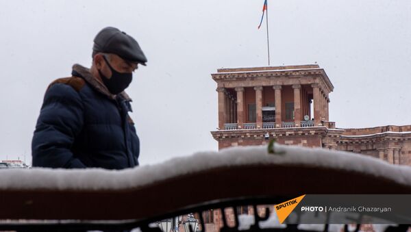 Мужчина проходит мимо скамьи на площади Республики (24 декабря 2020). Еревaн - Sputnik Արմենիա