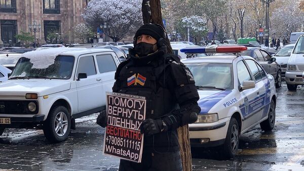 Активист с плакатом на площади Республики (24 декабря 2020). Еревaн - Sputnik Армения