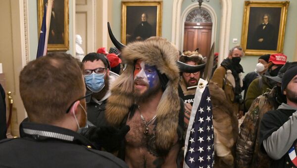 Сторонники президента США Дональда Трампа, в том числе член группы QAnon Джейк А, также известный как Йеллоустонский волк, входят в Капитолий после штурма (6 декабря 2021). Вашингтон - Sputnik Армения