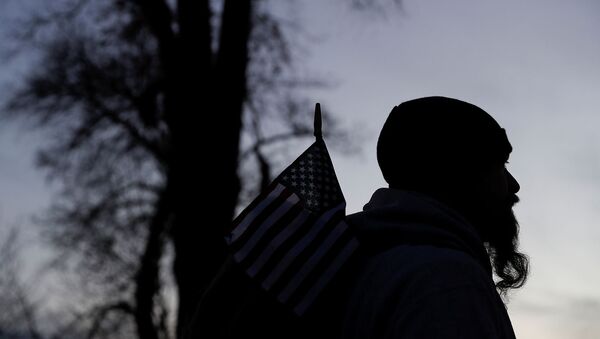 Силуэт мужчины с американским флагом перед зданием Капитолия США на следующий день после его штурма сторонниками президента США Дональда Трампа (7 января 2021). Вашингтон - Sputnik Армения