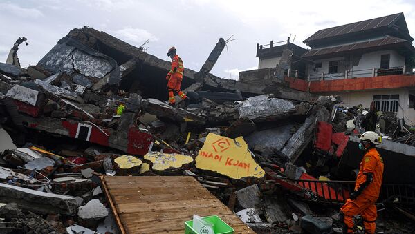 Поисково-спасательный персонал осматривает обрушившееся здание после землетрясения в Мамуджу (16 января 2021). Индонезия - Sputnik Արմենիա