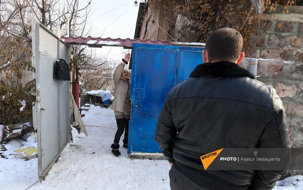 Мать мужчины, взявшего в заложники 3-летнего сына, Нвард, вместе с сотрудниками следственного отдела у ворот дома (27 января 2021). Еревaн - Sputnik Армения