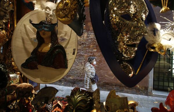 Женщина походит мимо витрины с карнавальными масками в Венеции  - Sputnik Армения