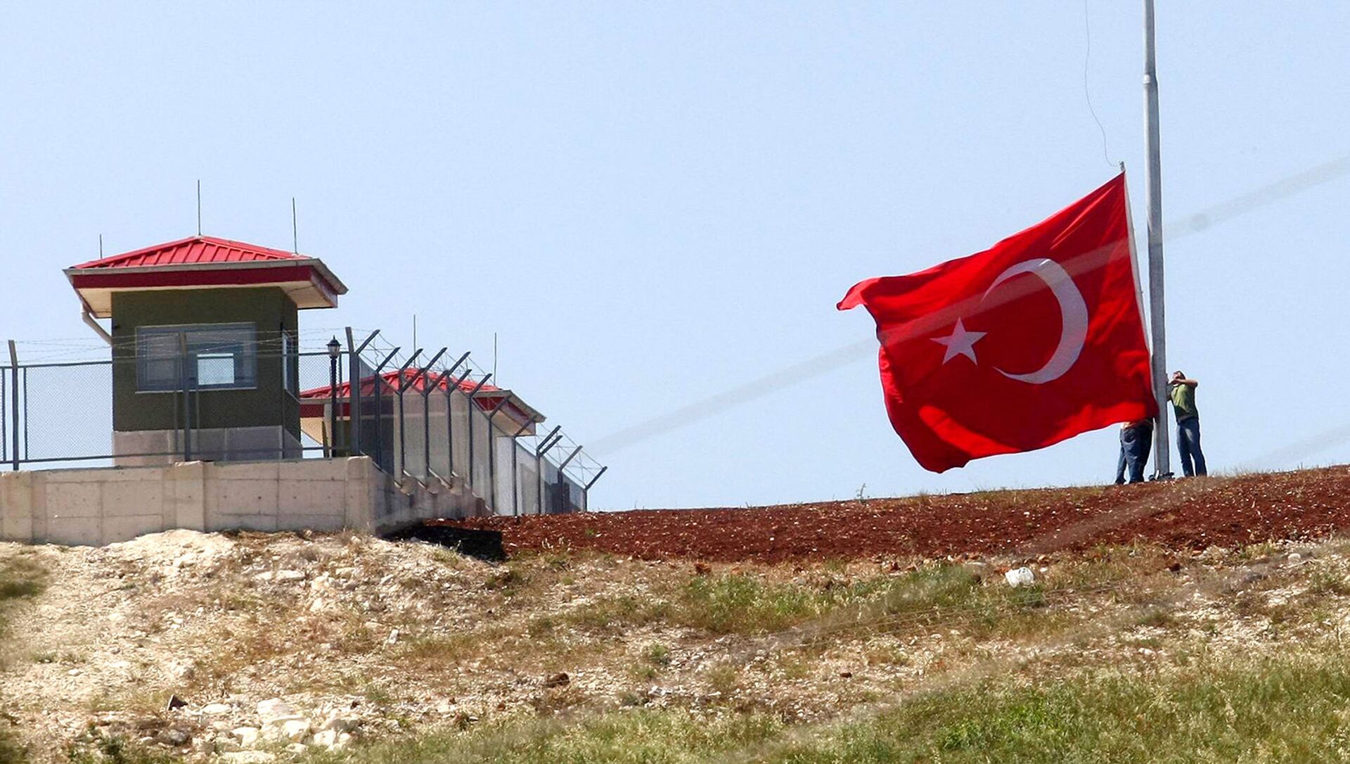 Турецкие солдаты поднимают флаг на пограничном посту на турецко-сирийской границе в деревне Гувеччи (23 июня 2011). Турция - Sputnik Армения, 1920, 24.02.2021