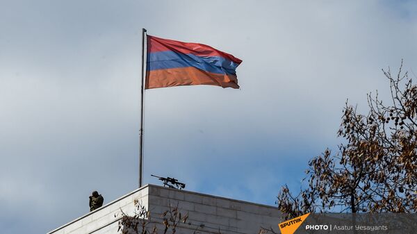 Сотрудник правоохранительных органов рядом с винтовкой на крыше здания МИД Армении (13 марта 2021). Еревaн - Sputnik Армения