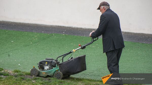 Пожилой мужчина стрижет газон - Sputnik Армения