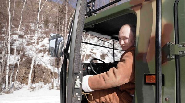 Президент РФ Владимир Путин управляет вездеходом во время прогулки в тайге - Sputnik Армения