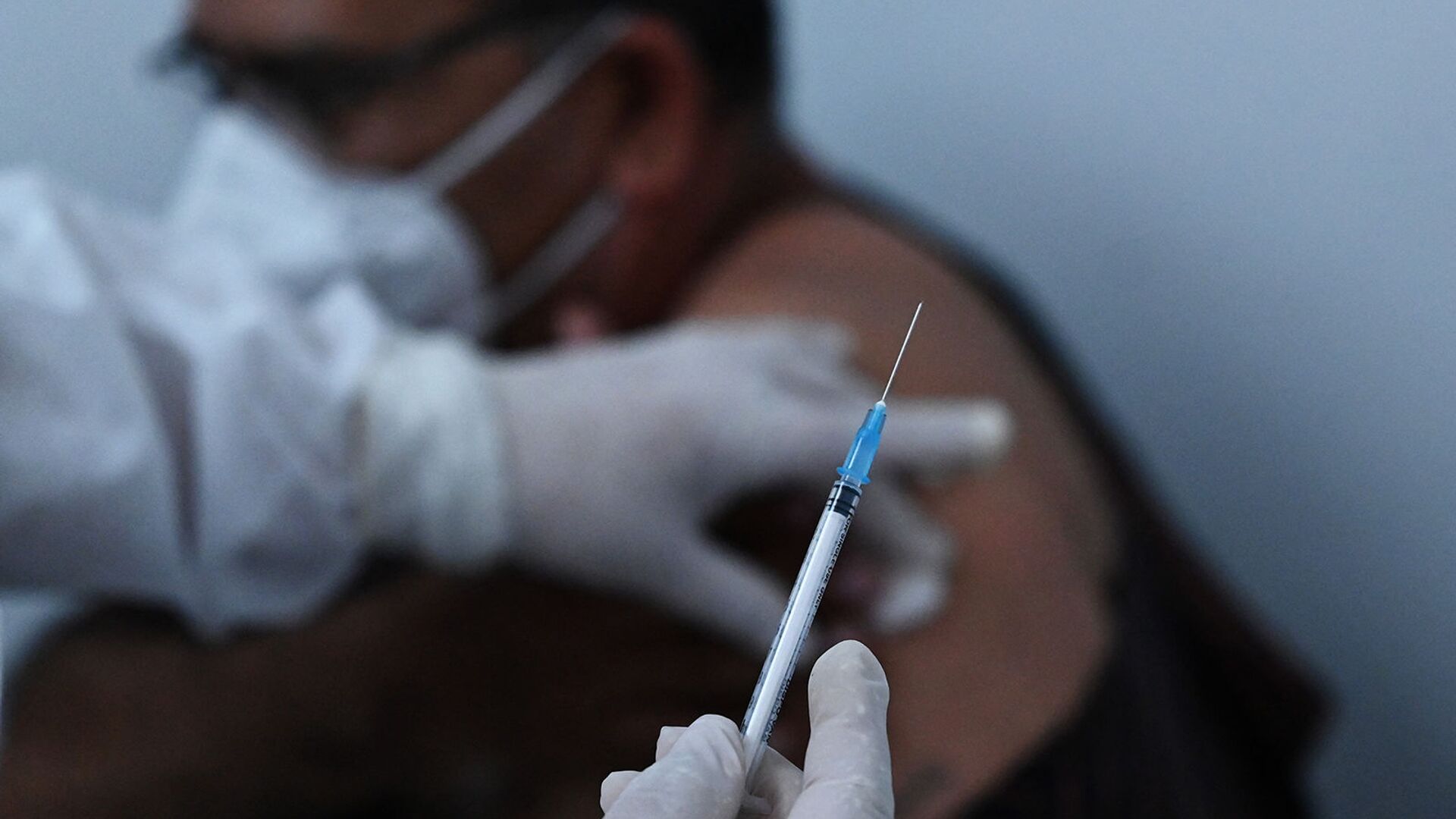 Медицинский работник вводит вакцину пациенту (23 марта 2021). Сальвадор - Sputnik Армения, 1920, 07.06.2022