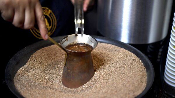 Мексиканский бариста готовит фирменный турецкий кофе в медном горшочке на горячем песке, Мехико - Sputnik Армения