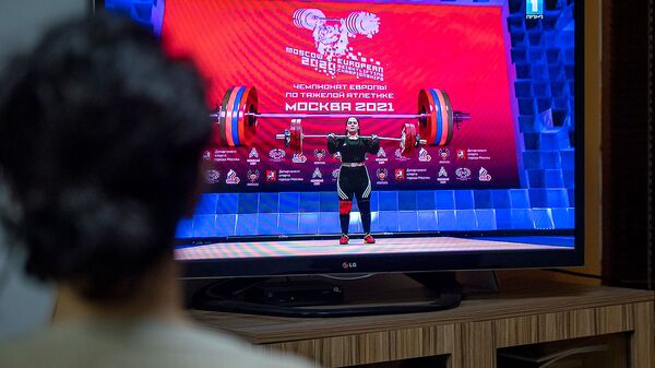 Девушка наблюдает за выступлением армянской тяжелоатлетки Татев Акопян на чемпионате Европы в Москвe (10 апреля 2021). Еревaн - Sputnik Արմենիա
