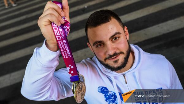 Самвел Гаспарян, занявший первое место в весе до 102 кг на Чемпионате Европы 2021 по тяжелой атлетике, показывает свои медали - Sputnik Армения