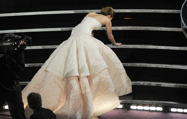 Ջենիֆեր Լոուրենսը սայթաքում է իր «Օսկարը» ստանալու համար բեմ բարձրանալիս։ Նա ճանաչվել էր «Լավագույն դերասանուհի» 2013 թվականին «Օսկար» մրցանակի հանձնման 85-րդ արարողության ժամանակ։ - Sputnik Արմենիա