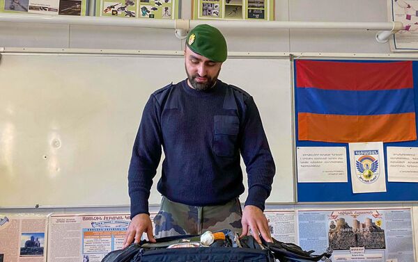 Бывший легионер Левон Мхламян во время обучающего урока для молодежи показывает содержимое своей дорожной сумки - Sputnik Армения