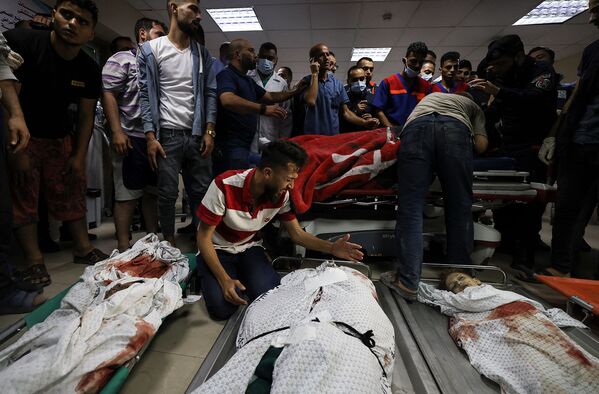 Родственники семьи Абу Хатаб скорбят по телам членов их семей в больнице Аль-Шифа после израильского удара по лагерю беженцев аш-Шати (15 мая 2021). Газа - Sputnik Армения