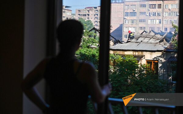 Проживающий по соседству гражданин наблюдает за действиями спасателей на месте пожара на улице Сарьяна (18 мая 2021). Еревaн - Sputnik Армения