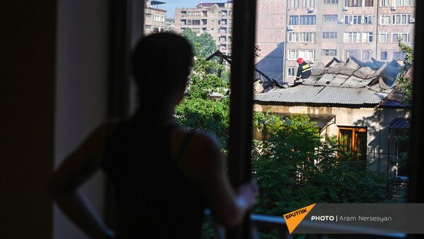 Проживающий по соседству гражданин наблюдает за действиями спасателей на месте пожара на улице Сарьяна (18 мая 2021). Еревaн - Sputnik Արմենիա