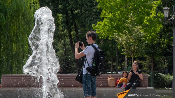 Молодой человек фотографирует фонтаны в парке 2800-летия Еревана - Sputnik Армения