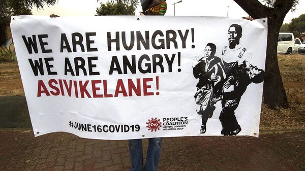 Мужчина держит плакат с надписью «Мы голодны, давайте защищать друг друга» (16 июня 2020). ЮАР - Sputnik Армения