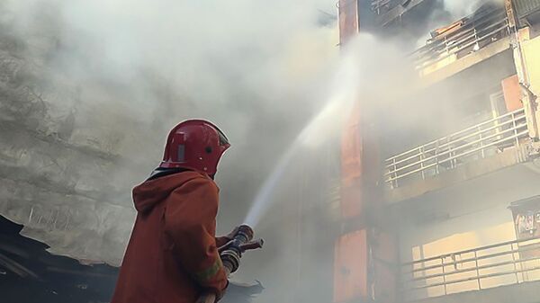Сотрудник пожарной службы МЧС тушит пожар в административном районе Эребуни - Sputnik Армения