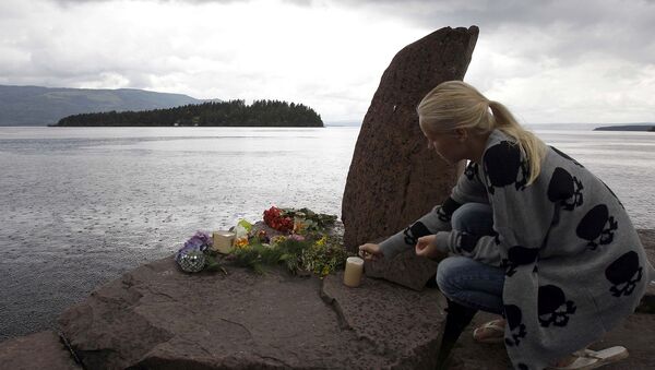 Женщина зажигает свечу у импровизированного мемориала жертвам Брейвика напротив острова Утоя в Норвегии - Sputnik Արմենիա