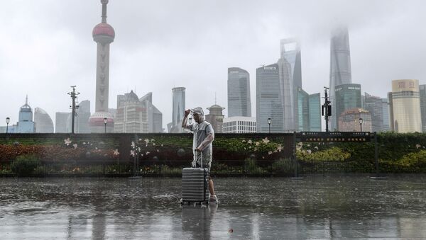 Мужчина с багажом перед началом тайфуна Иньфа (25 июля 2021). Шанхай - Sputnik Արմենիա