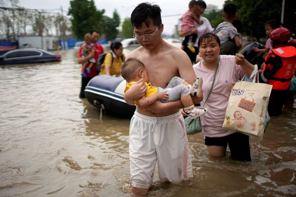Տղամարդը երեխայի հետ անցնում է ջրով ողողված փողոցով. Չինաստան - Sputnik Արմենիա