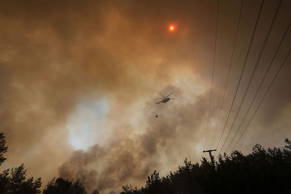 Пожарный вертолет возвращается после тушения лесного пожара возле Мармариса (30 июля 2021).  Турция - Sputnik Армения