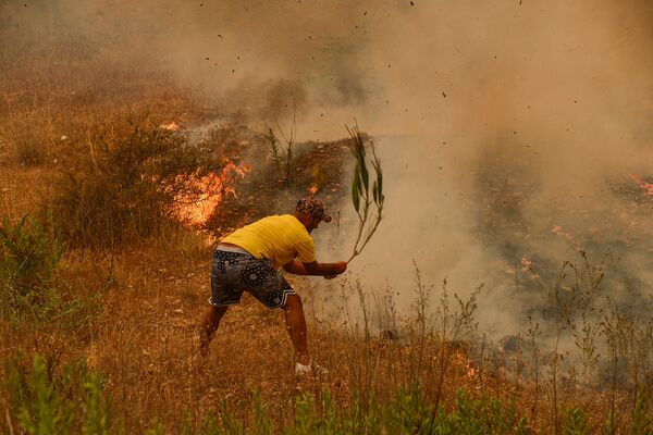 Мужчина пытается потушить горящие кусты во время сильного лесного пожара (29 июля 2021). Турция - Sputnik Армения